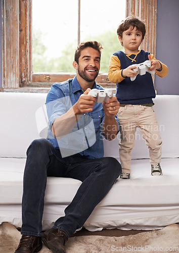 Image of Family, father and son on a sofa, video game and competition with bonding, loving or relax at home. Parent, happy dad or boy on a couch, playing and gamers in the living room, happiness or connection