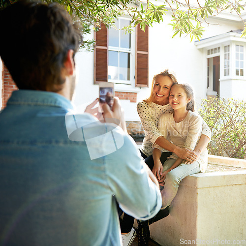 Image of Happy family house, outdoor hug and phone photo of Mothers Day kid, child or girl with mom, mama or woman. Dad, bond and people enjoy quality time together in backyard garden, embrace and smile