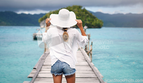 Image of Island, ocean and back of woman on deck for holiday, summer vacation and weekend getaway in Maldives. Traveling, tropical villa and female person on luxury resort for relax, happiness and adventure