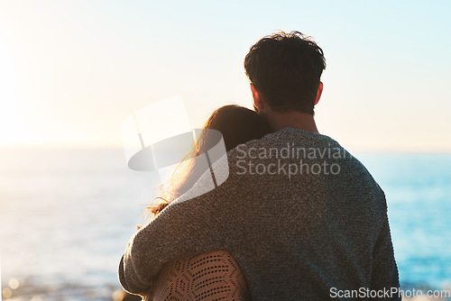 Image of Love, beach and couple hug at sunset for relaxing, bonding and quality time on romantic date. Nature, travel and man and woman embrace for anniversary or honeymoon on holiday, weekend and vacation