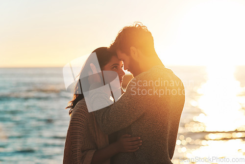 Image of Sunset, beach and couple touching face for relaxing, bonding and quality time on romantic date. Nature, love and man and woman embrace for anniversary or honeymoon on holiday, weekend and vacation