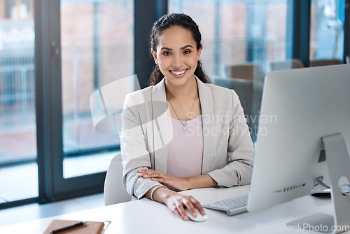 Image of Success, confidence and portrait of a businesswoman in the office while working on a computer. Happy, smile and professional female employee working on a corporate project on a pc in the workplace.