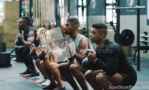 Image of Weightlifting, fitness and people with kettle bell in gym for training, exercise and workout class. Teamwork, body builder and men and women squat with weights for challenge, wellness and strength