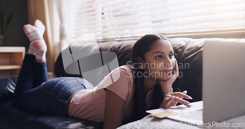 Image of Laptop, search and woman relax on a sofa with streaming, entertainment and subscription in her home. Online, social media and female person on a couch on day off with film or reading in a living room