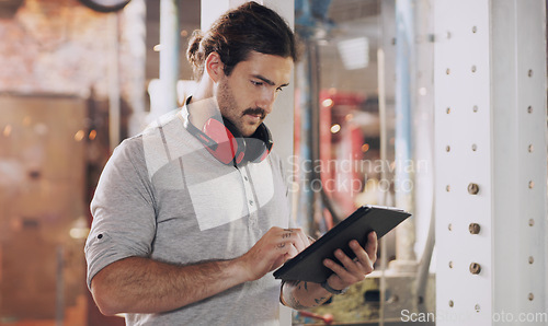 Image of Tablet, industry and planning with a man in a workshop for manufacturing, production or metal work. Logistics, construction and technology with an industrial engineer working in a factory or plant