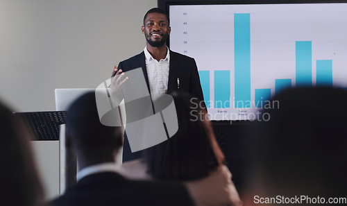 Image of Black man, presentation and speaker with business graphs at seminar, workshop or training. Men and women crowd at a conference for learning, knowledge and financial growth or development discussion