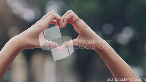 Image of Closeup, hands and woman with a heart shape, city and solidarity with support, care and review. Zoom, female person and girl outdoor, symbol and love with feedback, motivation and sign with emoji