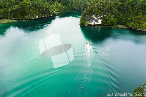 Image of Travel, aerial and boat on island river for adventure, holiday and vacation in Indonesia. Nature, seascape and drone view of yacht in tropical water for transport, sailing and traveling on islands