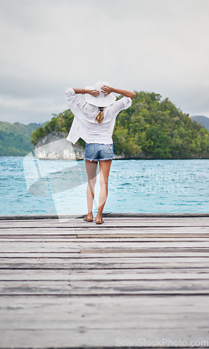 Image of Tropical island, ocean and woman on deck for holiday, summer vacation and weekend getaway in Maldives. Traveling, relax and back of female person on luxury resort for tourism, happiness and adventure