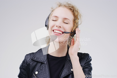 Image of Call center, woman and listen in studio with headset, smile and communication for tech support by white background. Crm girl, telemarketing and customer service with mic, voip or happy for consulting