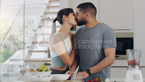 Image of Love, cooking and couple kissing in kitchen while preparing a healthy, fresh and diet breakfast. Happy, bonding and young man and woman with intimate moment while cutting fruit for smoothies together