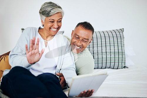 Image of Digital tablet, video call and senior couple speaking, waving and bonding on a sofa in their house. Happy, smile and elderly man and woman in retirement on a virtual conversation with mobile at home.