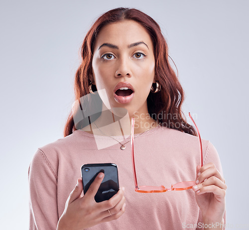 Image of Portrait, connection and woman with a smartphone, surprise and communication against a studio background. Face, female person or model with shock, cellphone and mobile app with network and connection