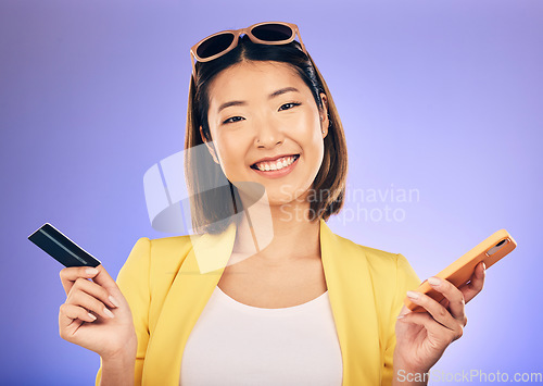 Image of Phone, credit card and portrait of a woman in a studio for online shopping with a positive mindset. Happy, smile and Asian female model with internet banking for paying bills by a purple background.