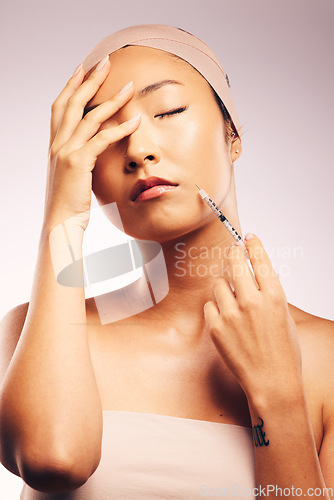 Image of Beauty, botox and woman in a studio with a syringe for an anti aging treatment for wrinkles. Skincare, cosmetics and Asian female model with a facial cosmetology injection isolated by gray background