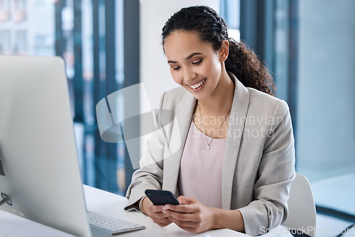 Image of Young business woman, texting and phone in office with smile, email communication and chat with online date. Businesswoman, smartphone and typing for contact, networking and social media app at desk