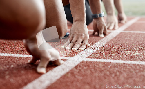 Image of Ground, hands and people ready for a race, running competition or training at a stadium. Fitness, sports and athlete runners in a line to start a sprint, exercise or challenge in track or athletics