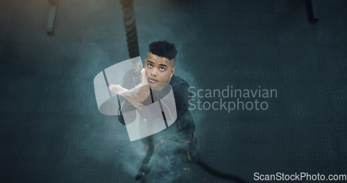 Image of Rope climbing, fitness and man at gym from above for training, performance and intense cardio on black background. Top view, climb and male with ropes, resilience and mindset during power workout