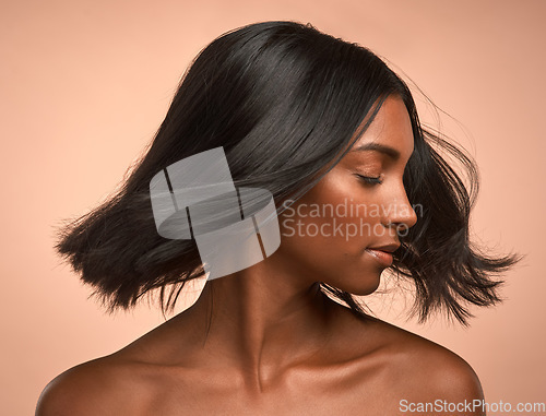 Image of Hair care, beauty and young woman in studio with keratin, healthy or brazilian salon treatment. Wellness, cosmetic and female model with motion for shiny, clean and soft hairstyle by brown background