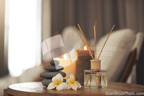 Image of Spa, aromatherapy and candles on table for zen, calm and peace to relax for health and wellness. Stones, flowers and diffuser for self care, holistic massage and hospitality at a beauty salon