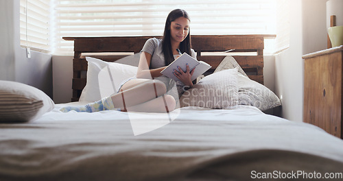 Image of Notebook, writing and woman in bed with a diary for idea, memory or personal entry in her home. Book, journal and female person with notes for brainstorming, idea and creative life goal in a bedroom