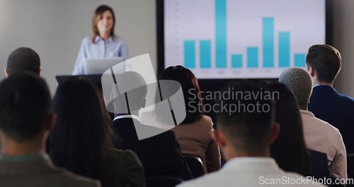 Image of Speaker, conference and business woman with graphs at a seminar, workshop or training. Professional men and women at a presentation with podium for learning, knowledge and discussion for sales growth