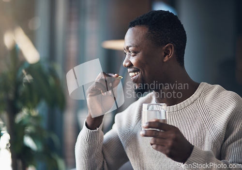 Image of Black man, pill or medicine and a glass of water in a house for health and wellness with a smile. Happy male person drinking pills, supplements or medication for healthcare, vitamins and energy
