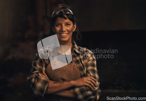 Image of Woman blacksmith, portrait and smile in workshop, industrial warehouse or trade with entrepreneurship. Small business owner, female entrepreneur or confident in factory, industry or metalwork artisan