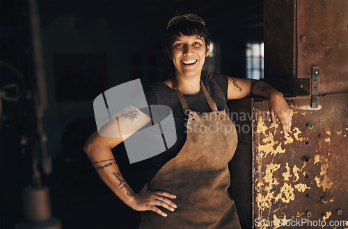 Image of Woman blacksmith, portrait and happy in workshop for industry, trade or entrepreneurship in foundry. Small business owner, female entrepreneur or labor in factory, industrial warehouse or metalwork