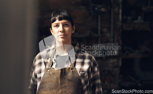 Image of Woman blacksmith, portrait and workshop at factory, trade or artisan job for entrepreneurship. Small business owner, female entrepreneur or labor in manufacturing, industrial warehouse or metalwork