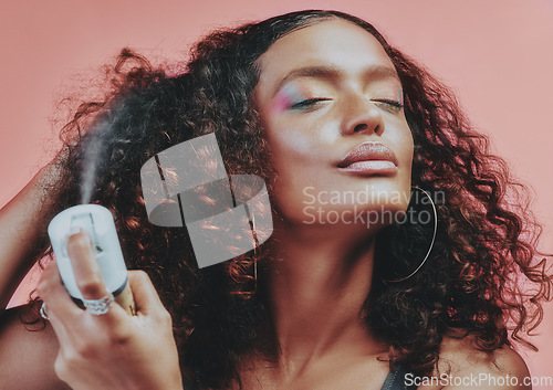 Image of Hairspray, curly hair and beauty with woman in studio for hairstyle, self care and natural. Skincare, makeup and cosmetics with female model isolated on pink background for pride, glow and texture