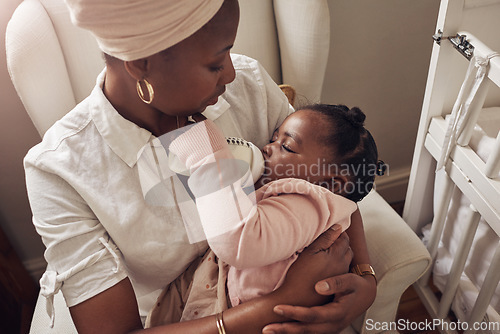 Image of Love, milk and bottle with mother and baby for care, nursing and morning. Smile, happiness and food with black woman and feeding newborn infant in family home for nutrition, wellness and growth