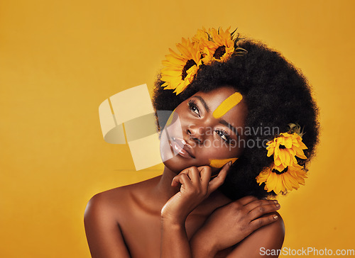 Image of Makeup, sunflower and black woman thinking in studio for beauty, wellness and treatment on yellow background. Flower, skincare and African female model relax while contemplating eco friendly cosmetic
