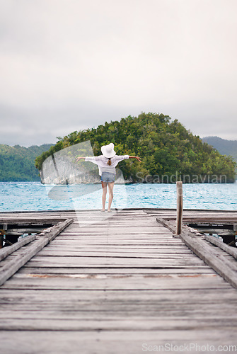 Image of Island, ocean and woman with freedom on boardwalk for holiday, summer vacation and weekend in Maldives. Travel, tropical sea and female person on luxury resort for carefree, happiness and relaxing