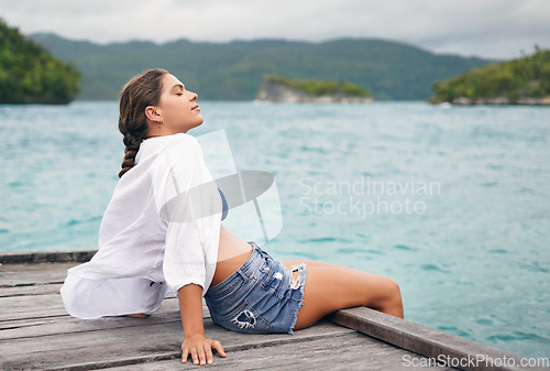 Image of Island, ocean and woman relax on deck for holiday, summer vacation and weekend getaway in Maldives. Traveling, tropical beach and calm female person on luxury resort for tourism, happiness or freedom