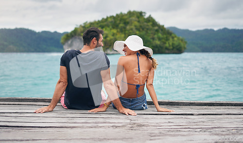 Image of Vacation, ocean and back of couple together on deck, dock or sitting on boardwalk to relax and enjoy the sea, water or landscape. People, man and woman on holiday, summer travel or date in nature