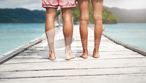 Image of Travel, island and legs of couple on deck for holiday, summer vacation and weekend in Maldives. Love, tropical and man and woman standing on luxury resort for honeymoon, anniversary and adventure