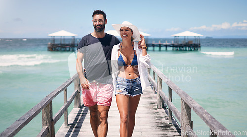 Image of Beach, island and couple walking on deck for holiday, summer vacation and tropical weekend in Maldives. Love, travel and happy man and woman on luxury resort for honeymoon, anniversary and adventure