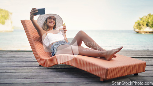 Image of Selfie, travel and woman with water, summer and happiness on a sun lounger, cocktail and tropical island. Female person, girl or happy tourist on a break, social media and drink to relax and cheerful