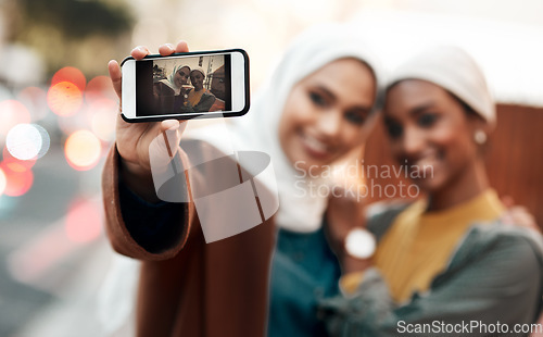 Image of Muslim woman, friends and selfie with phone in city for travel, urban adventure or post for social media app. Islamic women, smartphone photography and profile picture on internet, web or blog in cbd