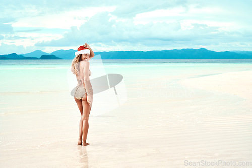 Image of Christmas hat, beach and woman with a smile, vacation and summer getaway with happiness, tropical island and relax. Portrait, female person and happy girl on a seaside holiday, Xmas cap and sunshine