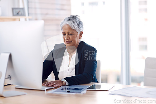 Image of Focus, computer and search with a business woman or CEO working in her corporate office. Serious, professional and leadership with a senior female manager at work typing an email or proposal