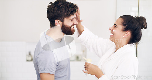 Image of Couple, face skincare cream and bathroom with smile, helping hand and morning together in home. Woman, man and skin wellness for help, care or laughing with product for lifestyle, beauty or health