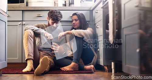 Image of Ice cream, love and couple on kitchen floor for bonding, relax and quality time together at home. Dating, relationship and happy man and woman with sweet food, dessert and marriage with romance