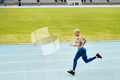 Image of Woman, stadium and athlete running on track for exercise, cardio training or workout outdoors. Fit, active or sporty female person or runner in sports fitness, run or race for athletics or wellness