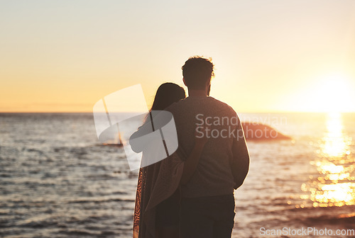 Image of Sunset, beach and couple hug by ocean in evening on holiday, summer vacation and weekend. Nature, love and man and woman embrace, hugging and relax for bonding, quality time and peace in evening
