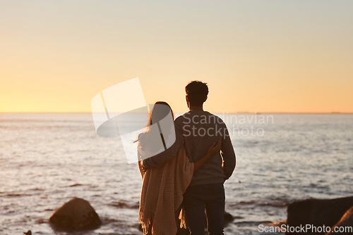 Image of Hug, sunset and couple relax on beach in evening on holiday, summer vacation and weekend by ocean. Nature, love and man and woman embrace, hugging and calm for bonding, quality time and peace by sea