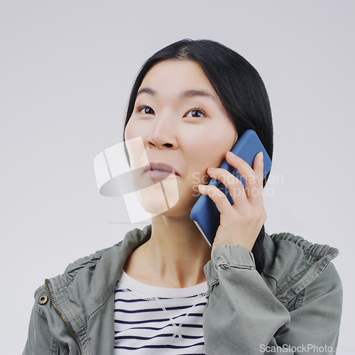 Image of Gossip, phone call and Asian woman talking in studio isolated on a white background. Listening, cellphone and female person speaking, discussion or communication for conversation, news or online chat