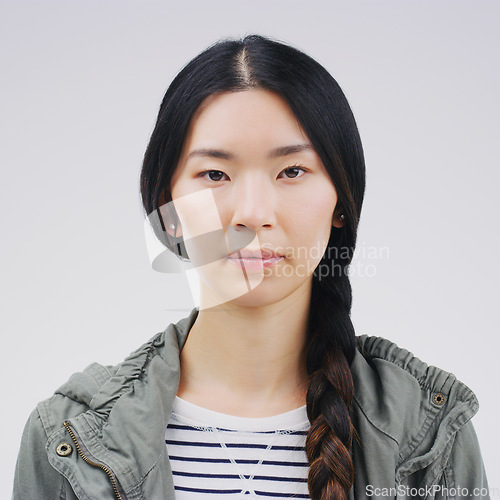 Image of Face, serious portrait and asian woman in studio with concentration and focus. Headshot of a young female student or natural model from Japan with casual clothes isolated on a white background