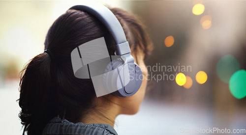 Image of Woman with headphones in city, back view and listening to music, bokeh and technology outdoor. Mockup space, podcast or radio streaming with female person in urban street and audio playlist